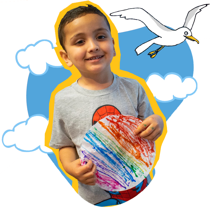 Ways-to-Give-child Child at SDCDM holding up his art smiling for picture