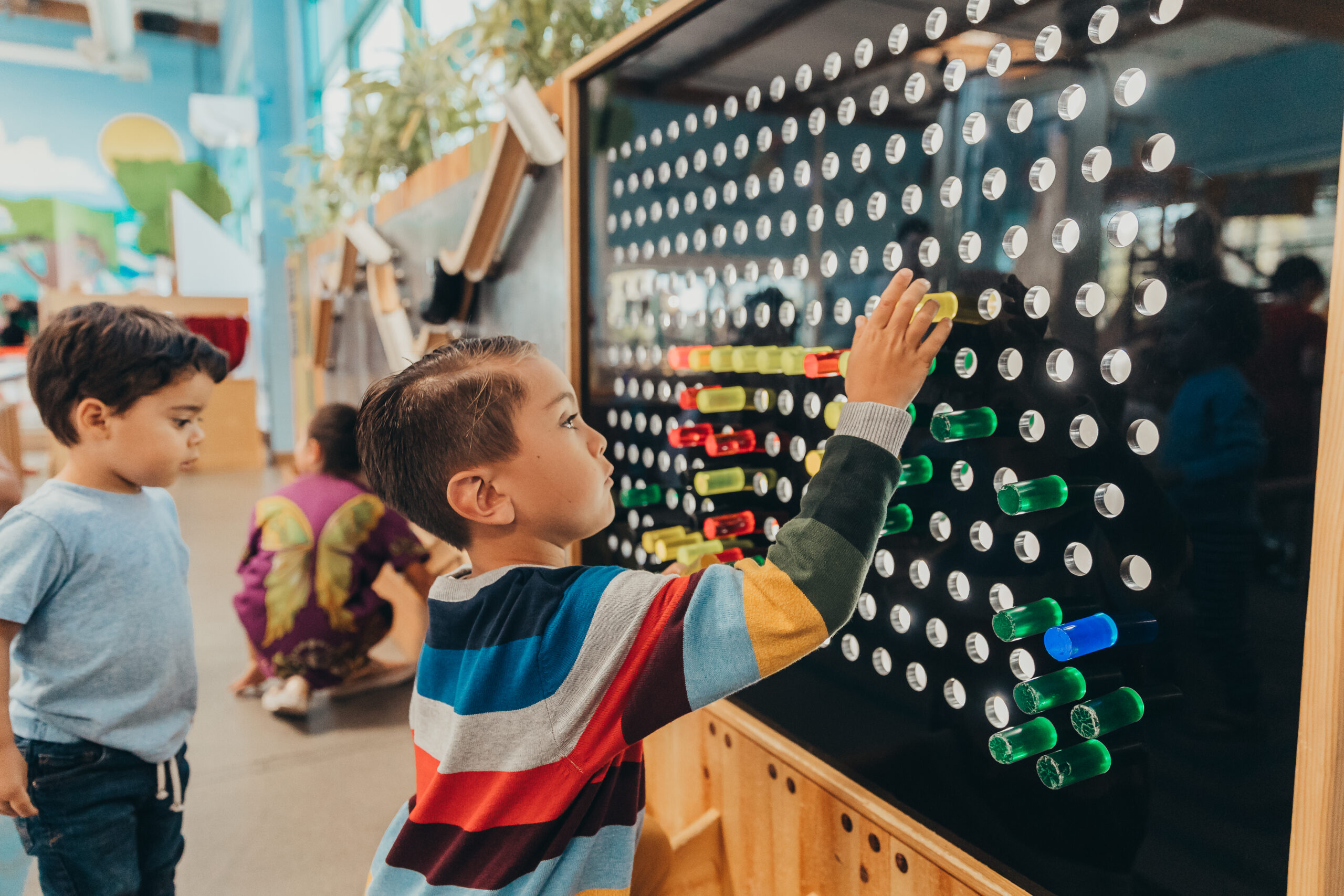 Child at SDCDM playing with peg board