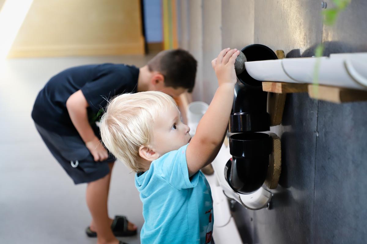 Child at SDCDM playing with plastic balls on wall