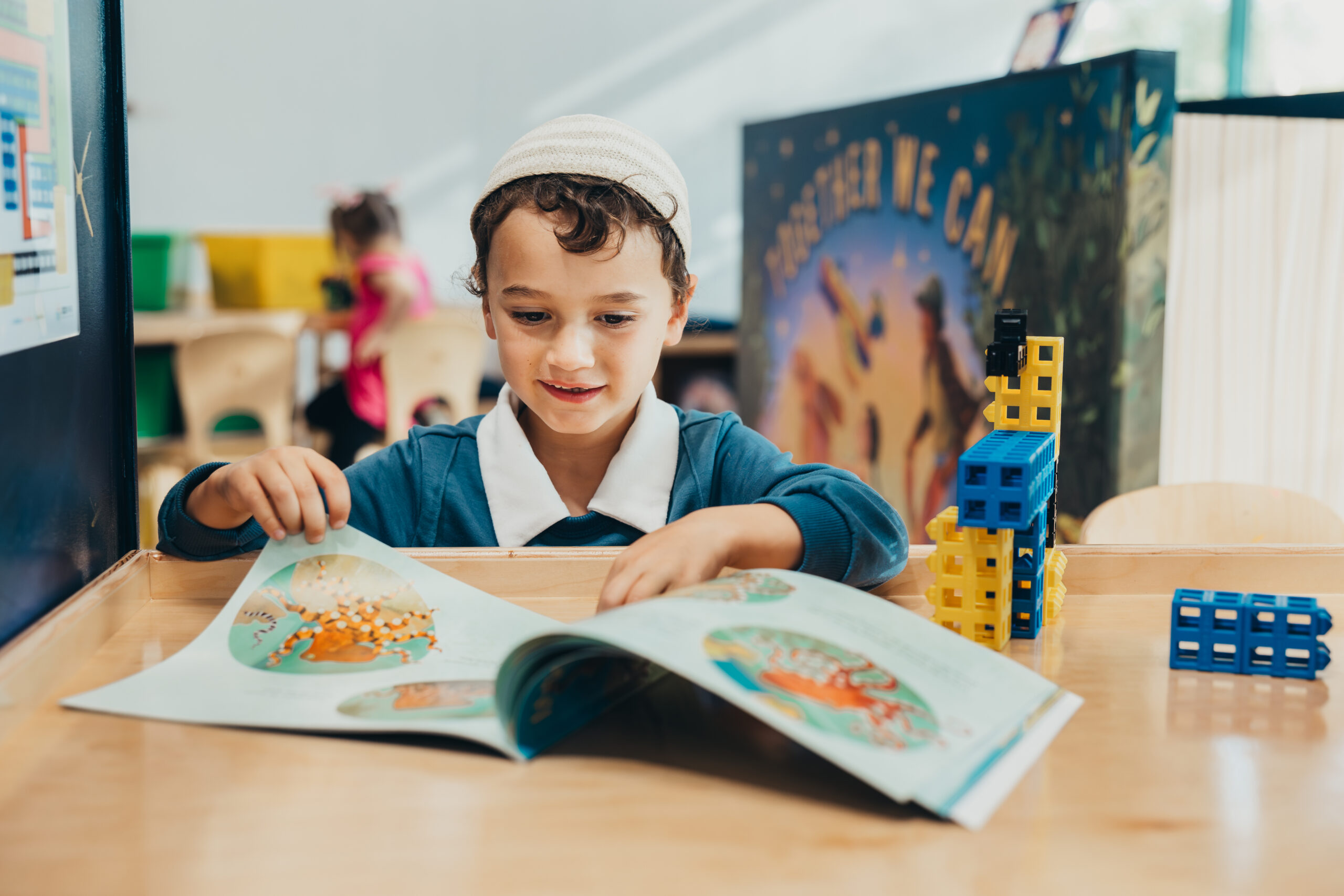 Child at SDCDM reading a book with octopus in it at a table