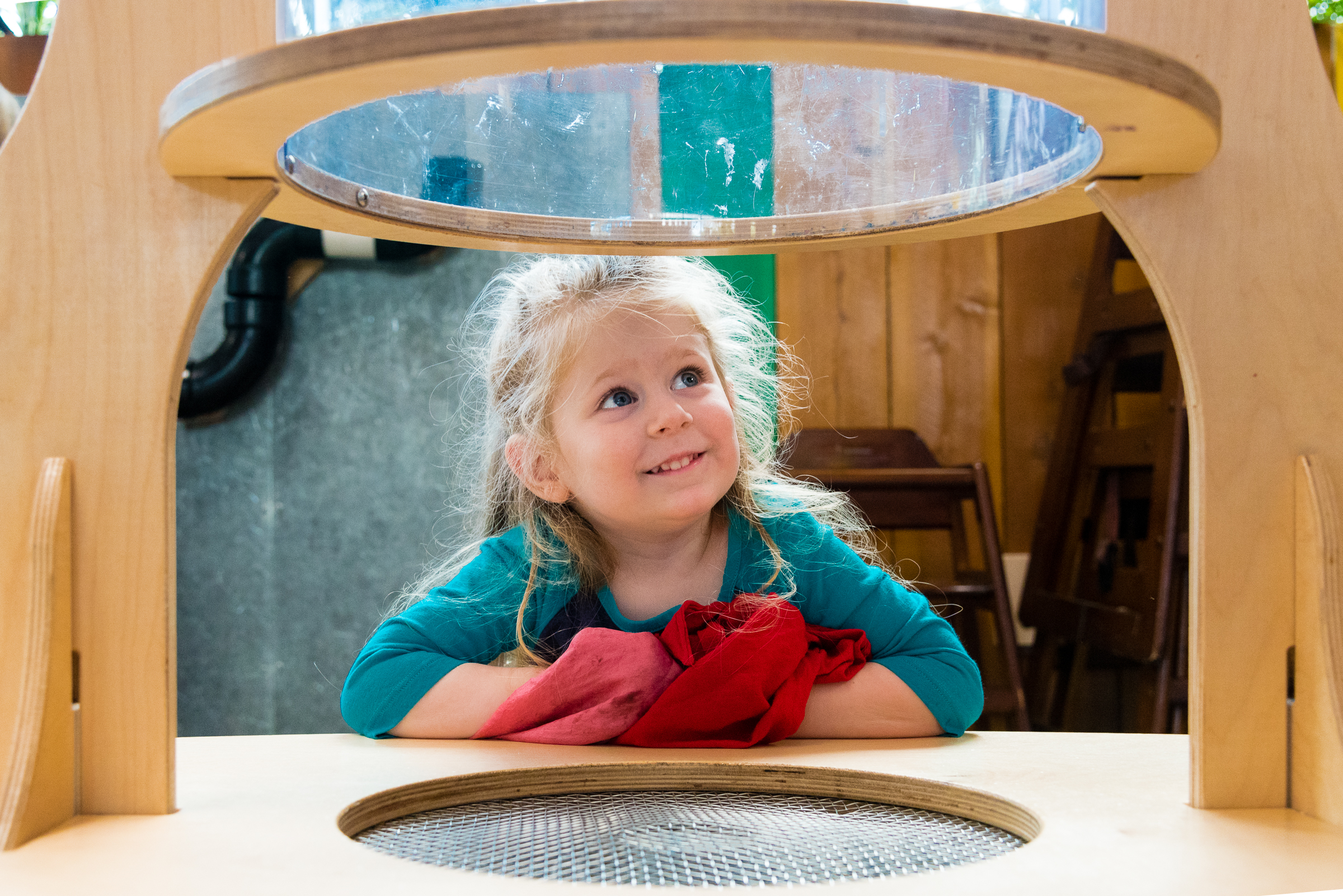 Child at SDCDM playing outside smiling while looking up