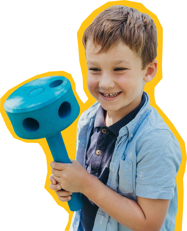 mobile-museum-child Child at SDCDM playing with a play mallet while smiling at camera