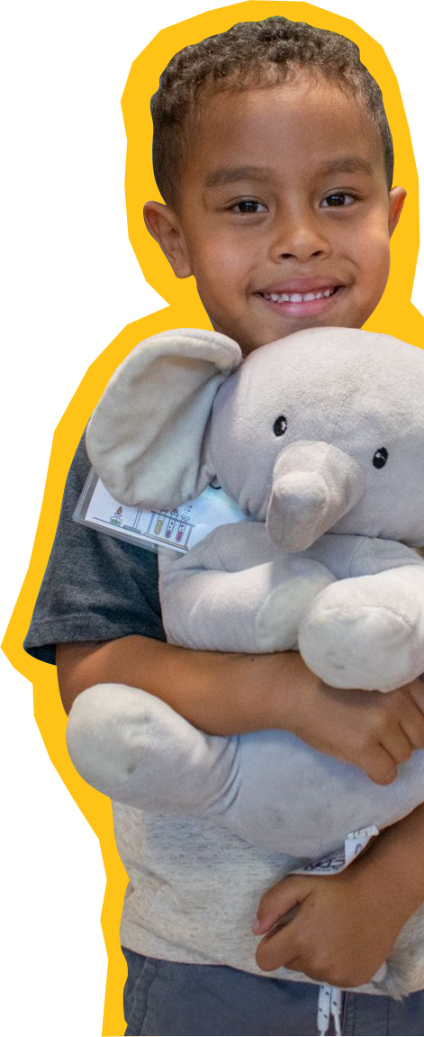 ways-to-give-kid boy holding a stuffed elephant