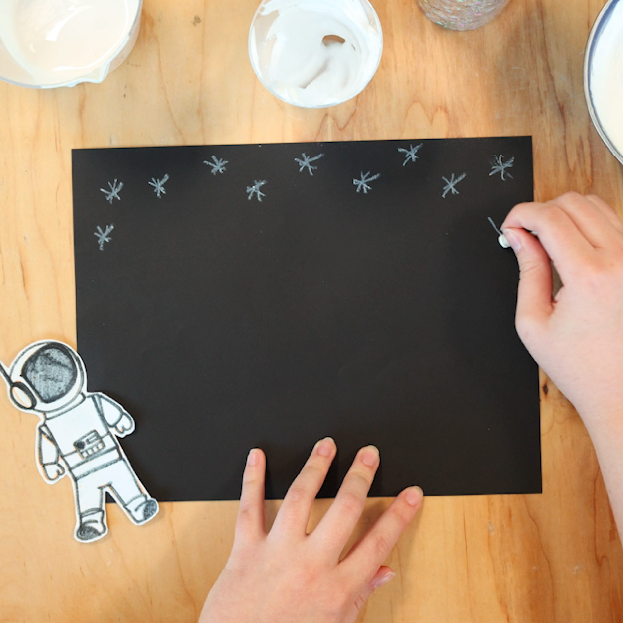 Draw stars on the black construction paper