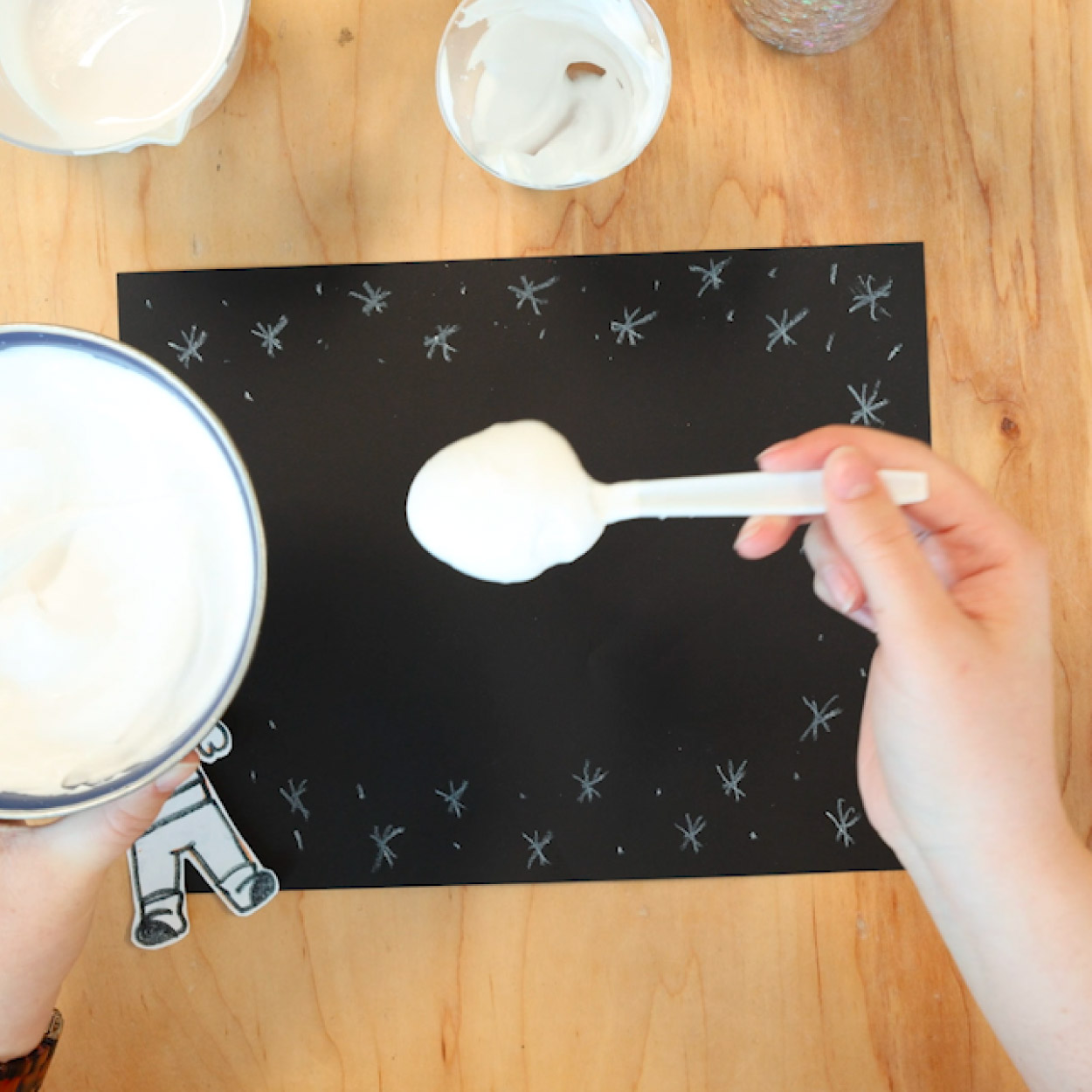 Add puffy paint to the black construction paper