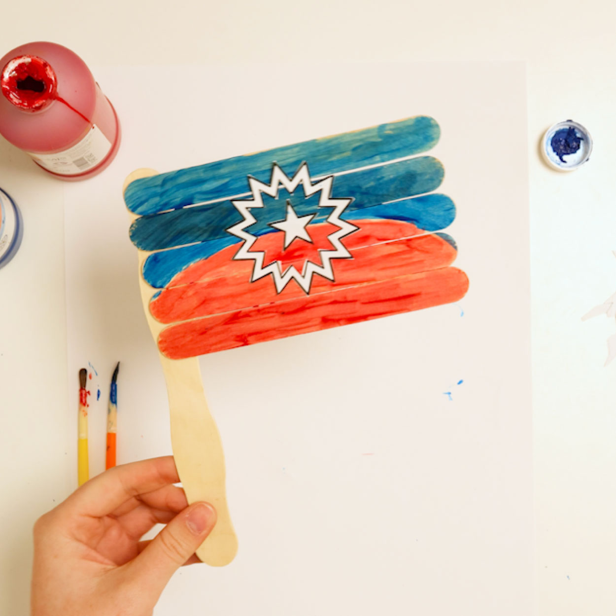 Juneteenth Step-09 Completed popsicle stick Juneteenth flag craft painted red and blue with a white bursting star