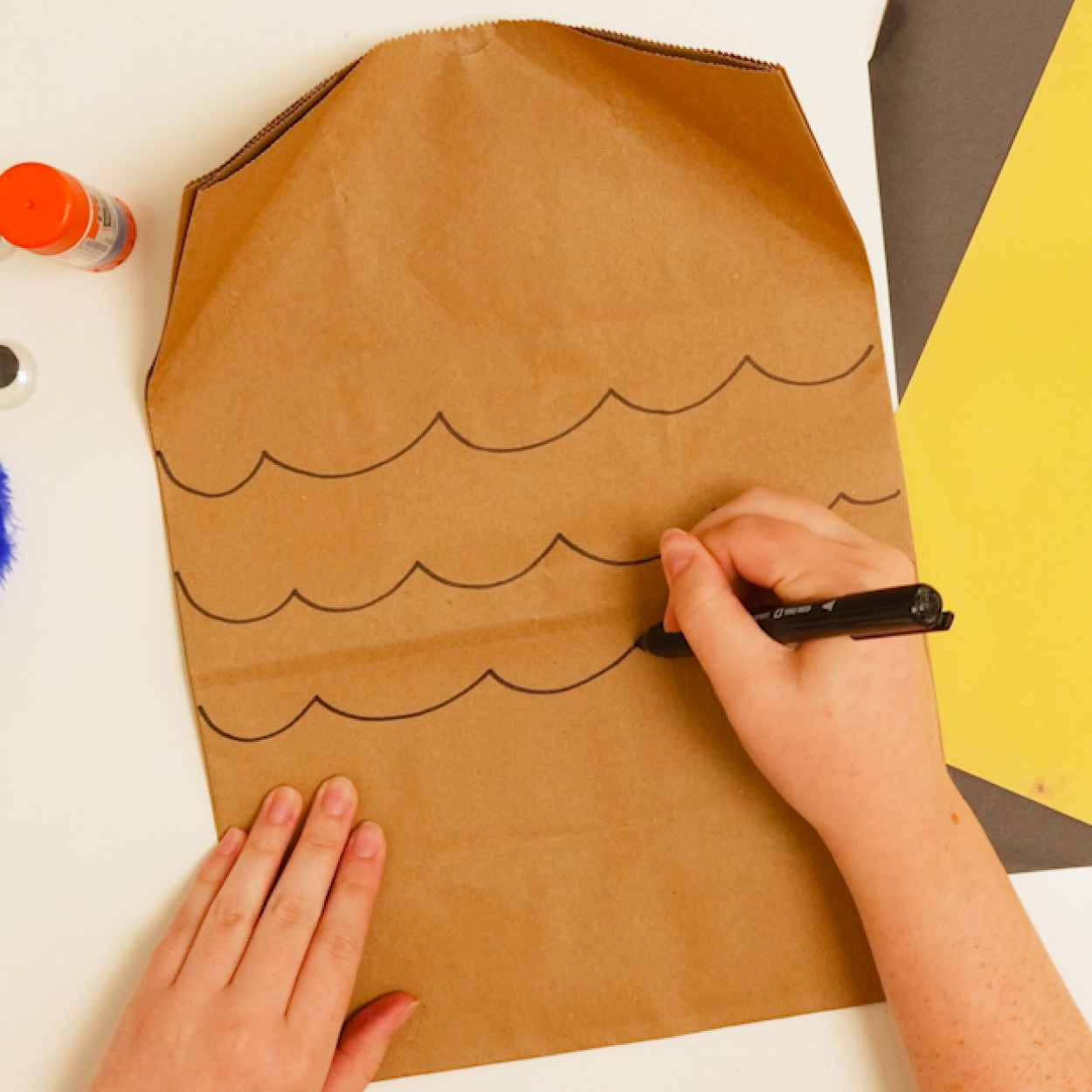 Draw feather patterns on the paper bag
